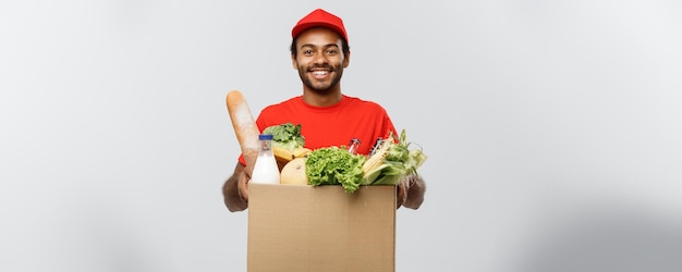 Concetto di consegna bell'uomo di consegna afroamericano che trasporta la scatola del pacchetto di generi alimentari e dr