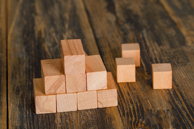 Concetto di crescita di affari con la piramide dei cubi di legno sulla vista di angolo alto della tavola di legno.