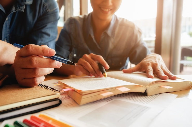 Foto gratuito concetto di educazione. studio studente e brainstorming campus concept. primo piano di studenti che discutono il loro tema su libri o libri di testo. messa a fuoco selettiva.