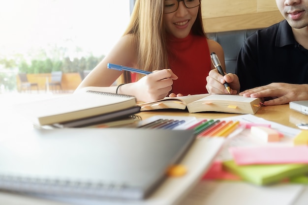 Concetto di educazione. Studio studente e brainstorming campus concept. Primo piano di studenti che discutono il loro tema su libri o libri di testo. Messa a fuoco selettiva.