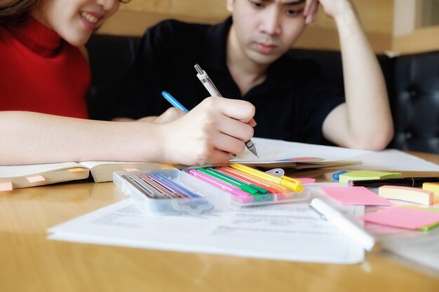 Concetto di educazione. Studio studente e brainstorming campus concept. Primo piano di studenti che discutono il loro tema su libri o libri di testo. Messa a fuoco selettiva.