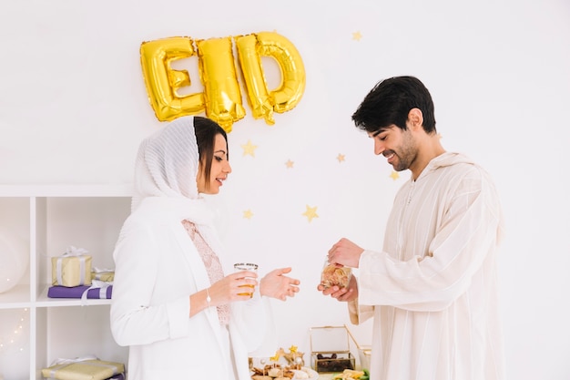 Concetto di Eid al-fitr con coppia che mangia i biscotti