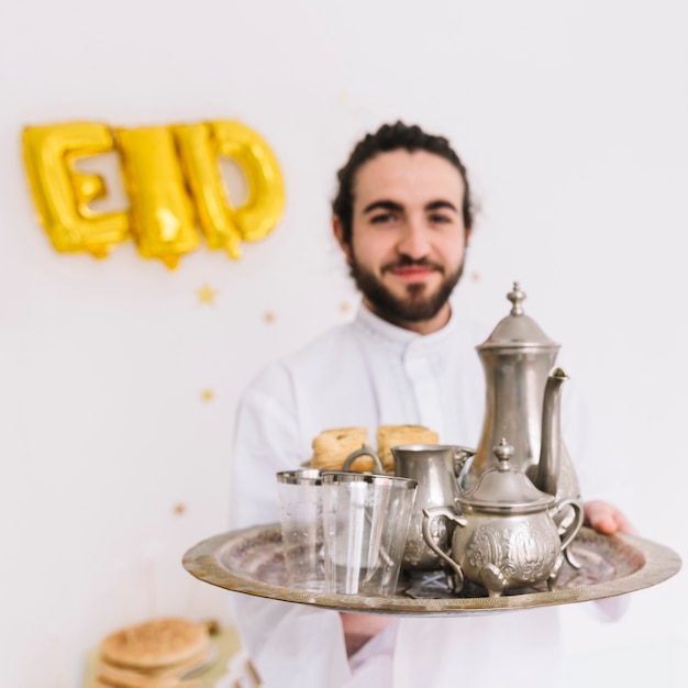 Concetto di Eid al-fitr con man holding piatto con tè