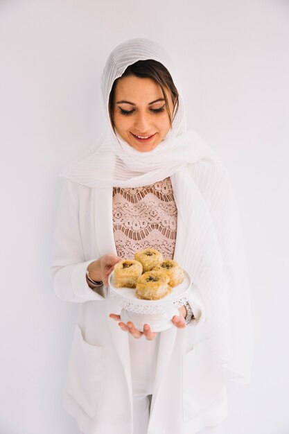Concetto di Eid con la donna che tiene pasticceria araba