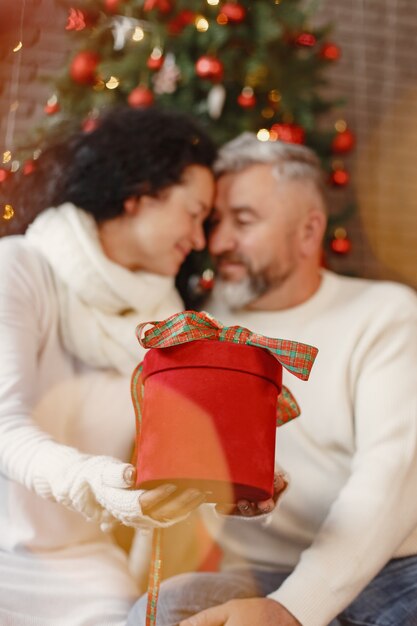 Concetto di età e persone. Coppia senior a casa. Donna in un maglione lavorato a maglia bianco.