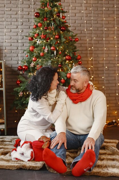 Concetto di età e persone. Coppia senior a casa. Donna in un maglione lavorato a maglia bianco.