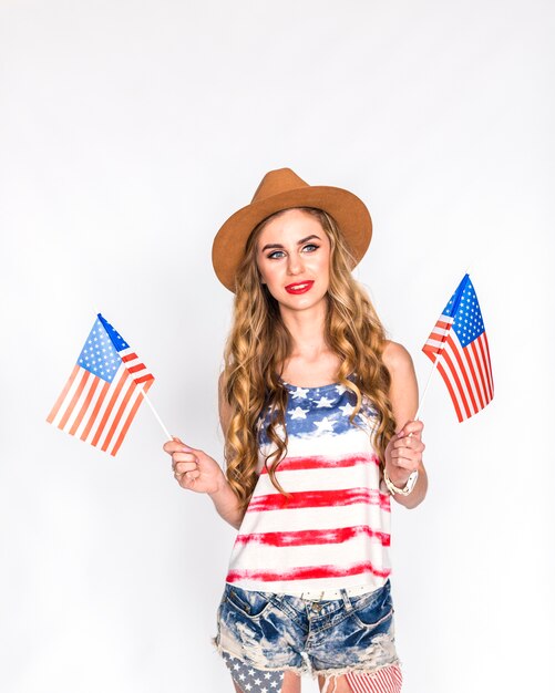 Concetto di festa dell&#39;indipendenza degli Stati Uniti con la donna che tiene due bandiere americane