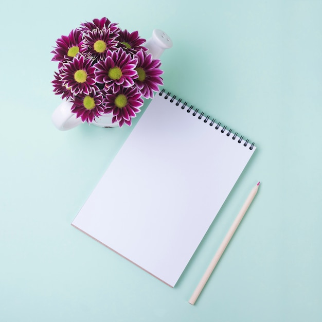 Concetto di fiori incantevole con notebook moderno