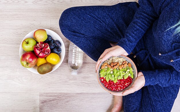 Concetto di fitness e stile di vita sano. La femmina sta riposando e sta mangiando una farina d'avena sana dopo un allenamento. Vista dall'alto.