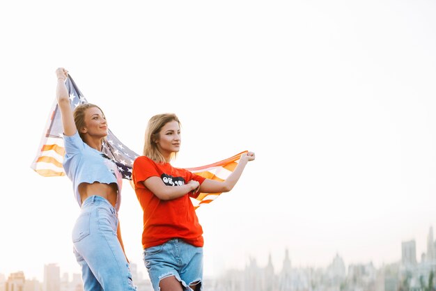 Concetto di giorno di indipendenza con le ragazze in piedi sul tetto