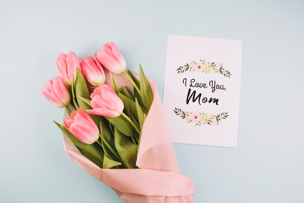 Concetto di giorno di madri con carta accanto al bouquet