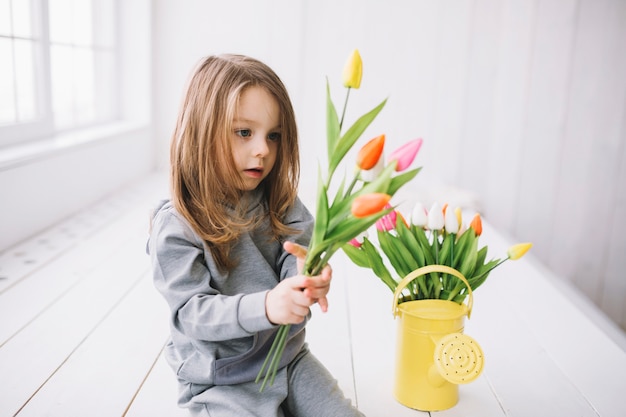 Concetto di giorno di madri con figlia guardando fiori