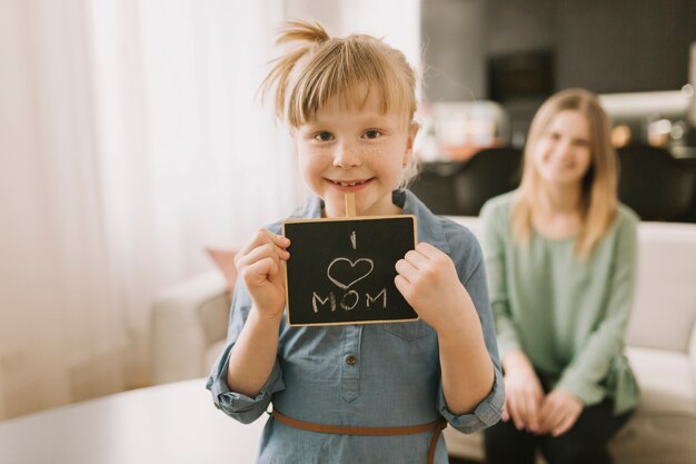 Concetto di giorno di madri con l&#39;ardesia della tenuta del bambino