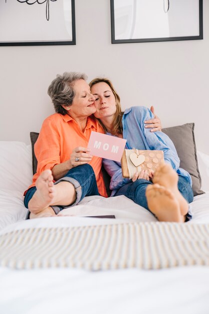 Concetto di giorno di madri in camera da letto con abbraccio