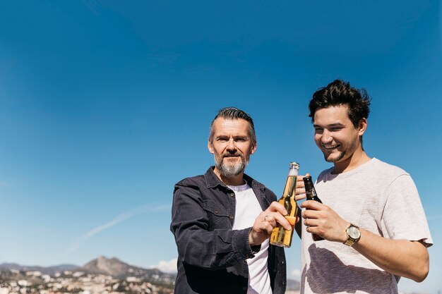 Concetto di giorno di padri con padre e figlio brindando con la birra