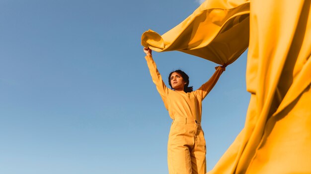 Concetto di libertà con il panno della tenuta della donna in natura