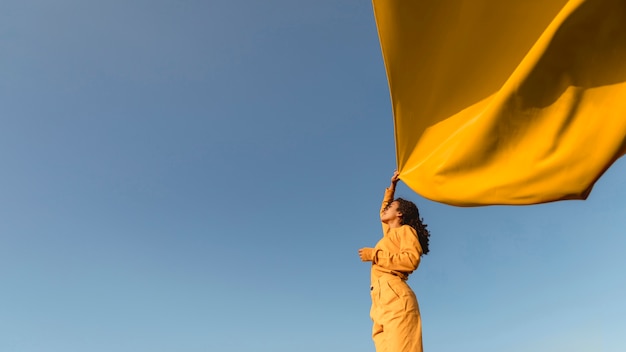 Concetto di libertà con il panno della tenuta della donna in natura