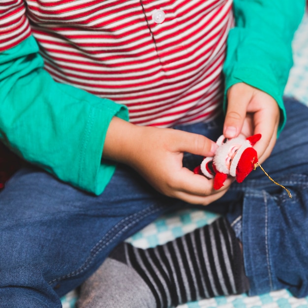 Concetto di Natale con il bambino che tiene la figura di Babbo Natale