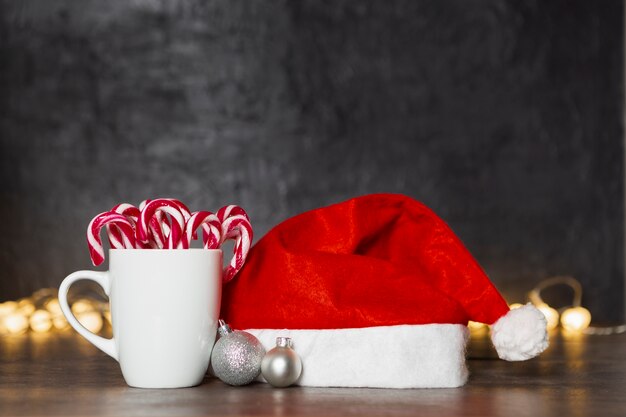 Concetto di natale con il cappello e la tazza della Santa con la caramella