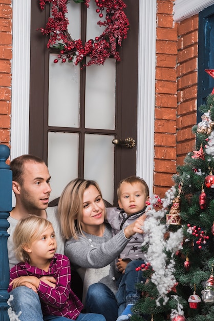 Concetto di Natale con la famiglia ammirando l&#39;albero di Natale