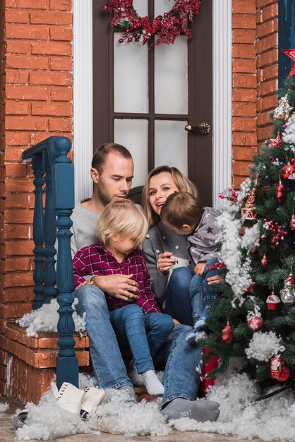Concetto di Natale con la famiglia seduti fuori