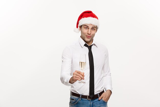 Concetto di Natale L'uomo d'affari bello festeggia il buon Natale e il felice anno nuovo indossa un cappello da Babbo Natale con un bicchiere di champagne