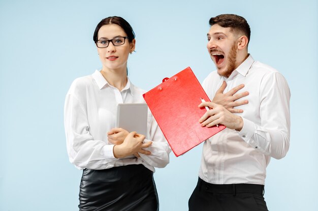 Concetto di partnership nel mondo degli affari. Giovane uomo sorridente felice e donna in piedi su sfondo blu