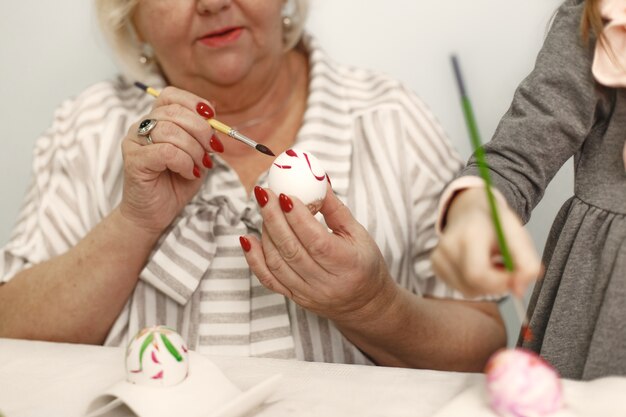 Concetto di Pasqua. Bambina e sua nonna colorare le uova per Pasqua.