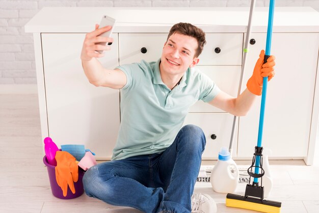 Concetto di pulizia con uomo che tiene smartphone