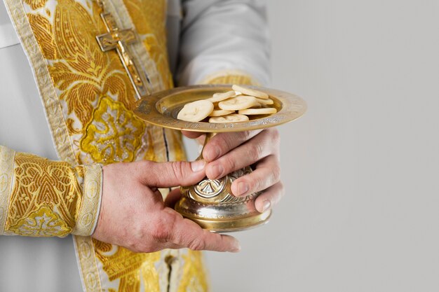 Concetto di santa comunione con il sacerdote che tiene il cibo