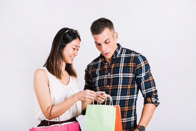 Concetto di shopping con coppia in cerca di borsa