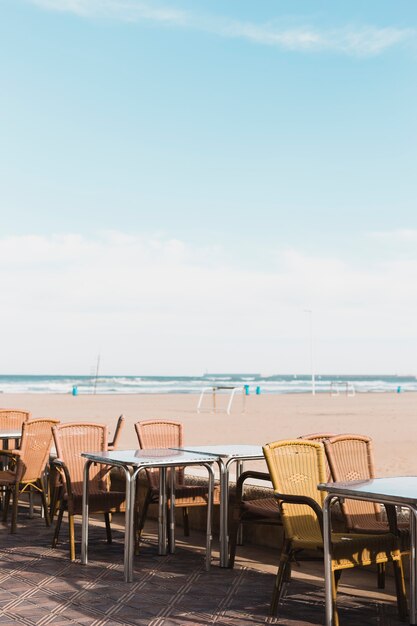 Concetto di spiaggia con tavoli e sedie
