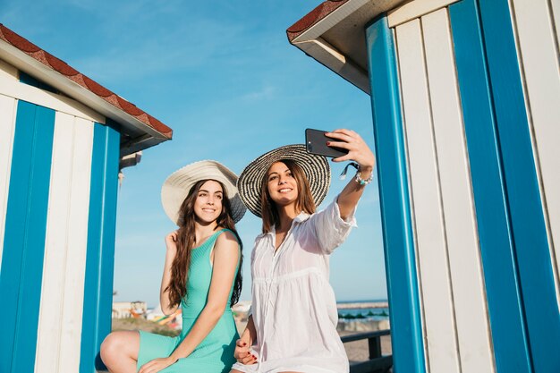Concetto di spiaggia e l&#39;estate con le donne prendendo selfie