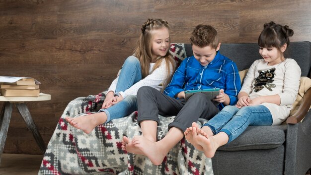 Concetto di tecnologia con i bambini sul divano