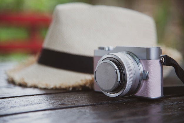 Concetto di viaggio di vista superiore con fotocamera e cappello sul tavolo