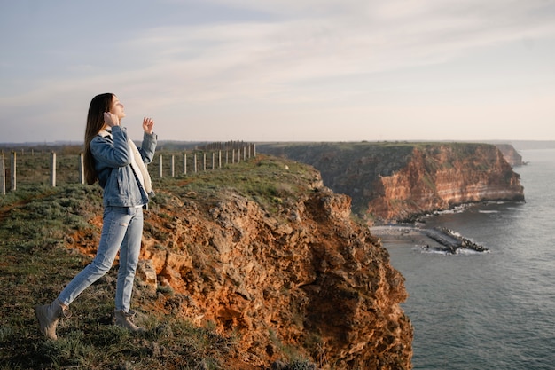 Concetto di voglia di viaggiare con la giovane donna che gode della natura