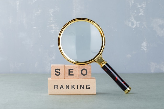 Concettuale di analisi seo e business. con blocchi di legno con parole su di esso, vista laterale lente di ingrandimento.