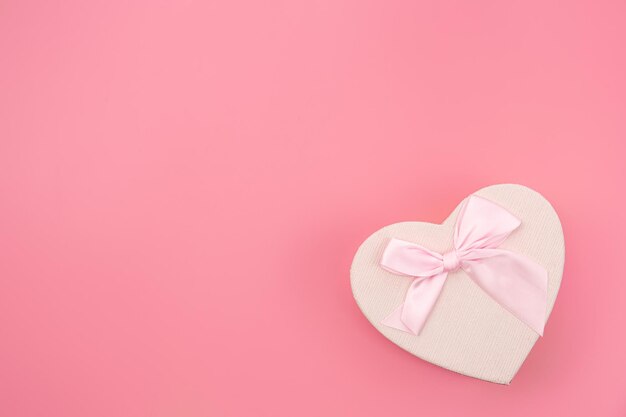 Confezione regalo a forma di cuore su sfondo rosa isolato