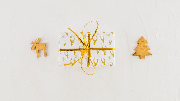 Confezione regalo in carta artigianale vicino cervo decorativo e abete