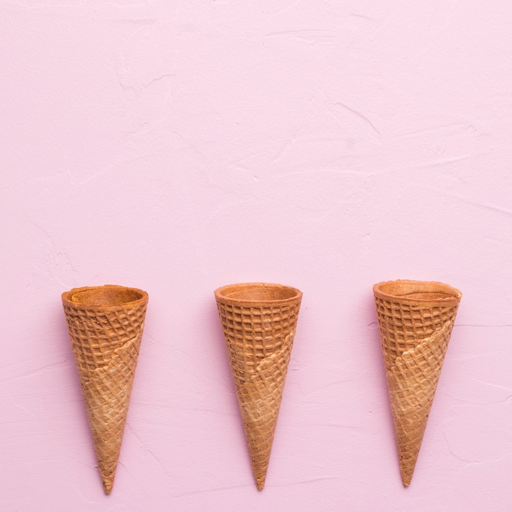 Foto gratuito coni gelati della cialda non riempiti sulla superficie di rosa