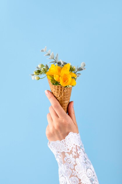 Cono gelato con fiori e sfondo blu