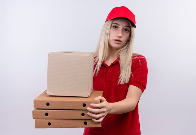 consegna giovane donna che indossa t-shirt rossa e berretto tenendo la scatola e la scatola della pizza sul muro bianco isolato