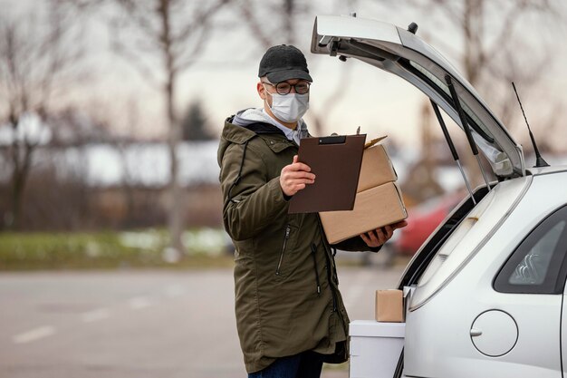 Consegna maschio con maschera e pacchi