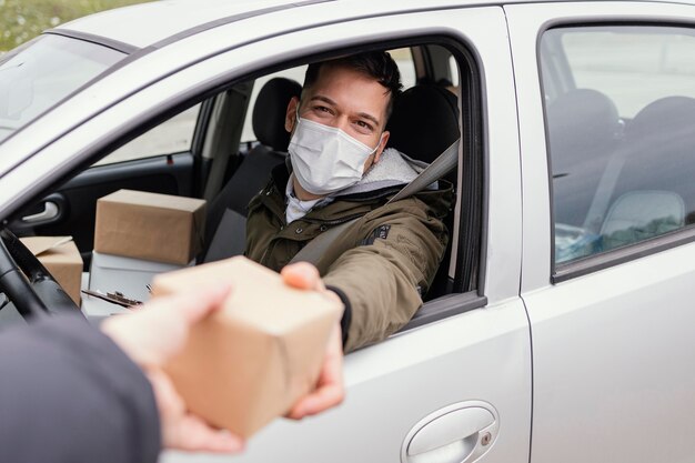 Consegna maschio con maschera e pacchi