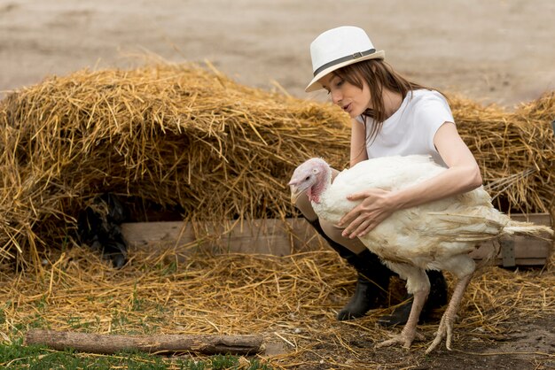 Contadino con un tacchino in una fattoria