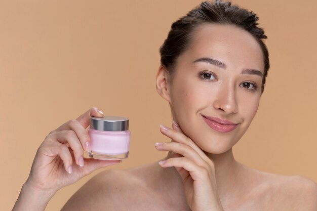 Contenitore di crema della holding della donna di vista frontale