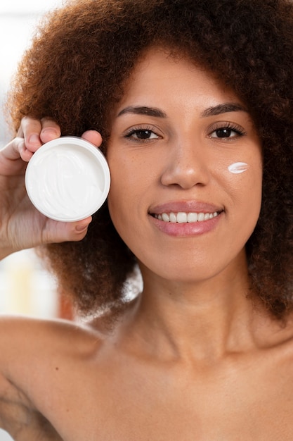 Contenitore di crema della holding della donna di vista frontale