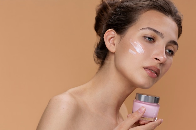 Contenitore di crema della holding della donna di vista laterale