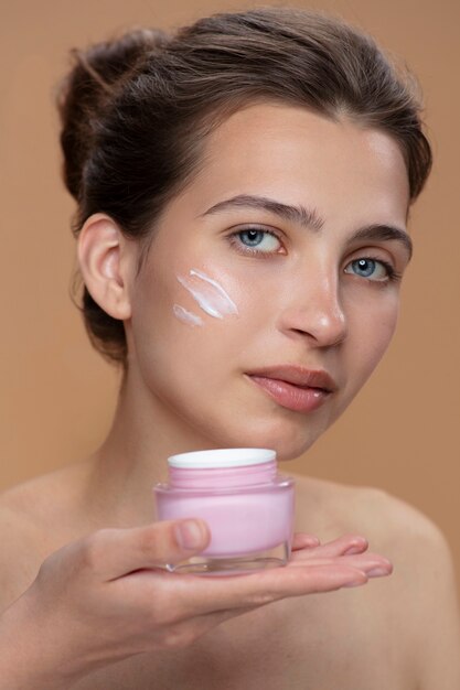 Contenitore di crema della holding della donna di vista laterale