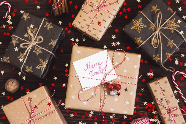 Contenitore di regalo di festa di Natale con cartolina buon Natale sul tavolo festivo decorato